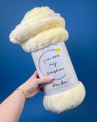 Shop the Bei Bei Faux Fur Petite Blanket in pink, blue, yellow, and white. A soft, fluffy baby blanket perfect for newborn gifts and baby showers.