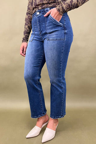 Person wearing blue jeans with a neutral background