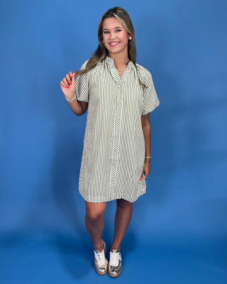 Woman wearing a striped dress against a blue background