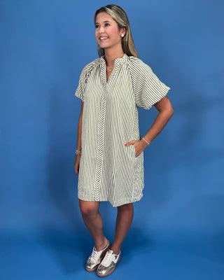 Woman wearing a striped dress against a blue background