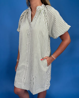 Woman wearing a striped dress against a blue background