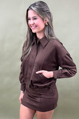 Woman wearing a brown outfit against a plain background