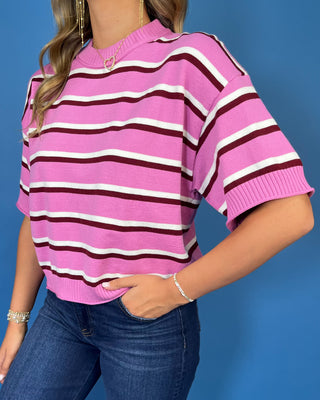 Pink short sleeve knit sweater top with burgundy and white horizontal stripes, a round neckline, and ribbed trim.