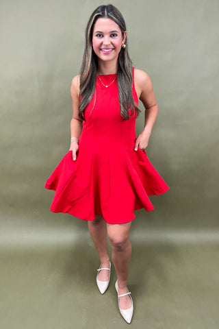 Woman wearing a red dress against a green background