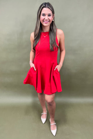 Woman wearing a red dress against a plain background