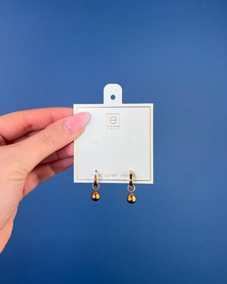 Shop the Enewton Huggie Hoop Gold Charm Earrings featuring polished gold hoops and dangling gold ball charms for timeless everyday style.