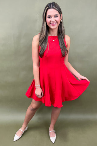 Woman wearing a red dress against a green background