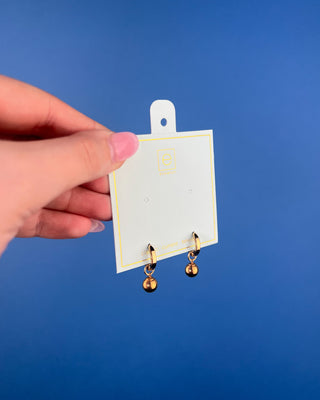 Shop the Enewton Huggie Hoop Gold Charm Earrings featuring polished gold hoops and dangling gold ball charms for timeless everyday style.