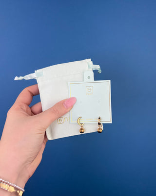 Shop the Enewton Huggie Hoop Gold Charm Earrings featuring polished gold hoops and dangling gold ball charms for timeless everyday style.