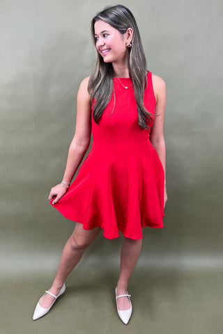 Woman wearing a red dress against a plain background