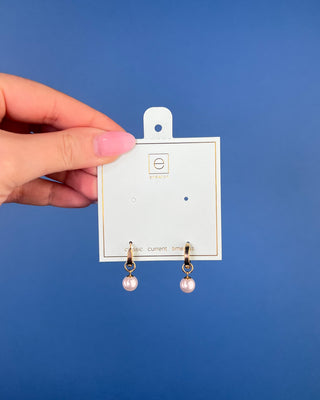 Shop the Enewton Huggie Hoop Pearl Charm Earrings featuring polished gold hoops and elegant dangling white pearl charms for timeless everyday style.