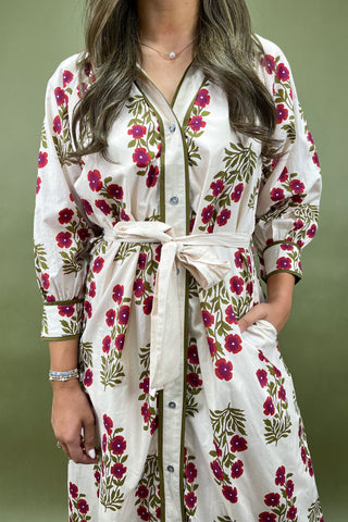 Woman wearing a white floral dress with a green background