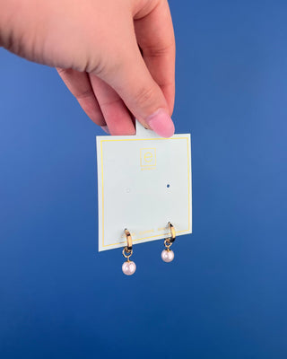Shop the Enewton Huggie Hoop Pearl Charm Earrings featuring polished gold hoops and elegant dangling white pearl charms for timeless everyday style.