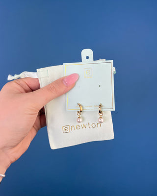 Shop the Enewton Huggie Hoop Pearl Charm Earrings featuring polished gold hoops and elegant dangling white pearl charms for timeless everyday style.
