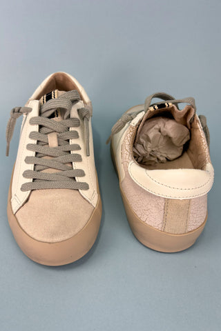 Pair of beige sneakers on a gray background