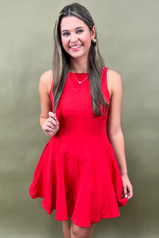 Woman wearing a red dress against a green background