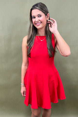 Woman wearing a red dress against a green background