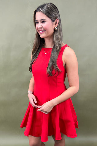 Woman wearing a red dress against a plain background