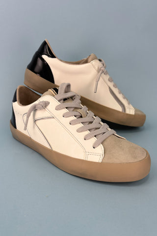 Pair of beige and brown sneakers on a gray background