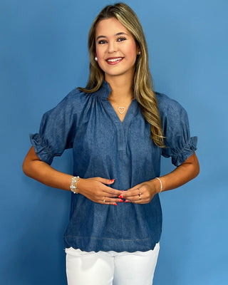 Woman wearing a blue blouse against a blue background