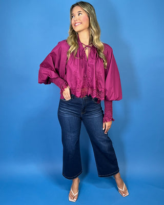 Magenta lace trim blouse with dramatic balloon sleeves, smocked cuffs, and a feminine tie-neck detail.