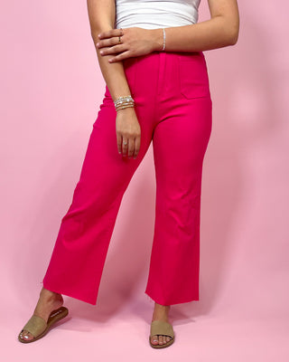 Person wearing bright pink pants on a pink background