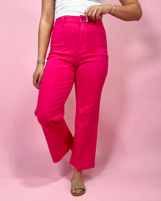Person wearing bright pink pants on a pink background