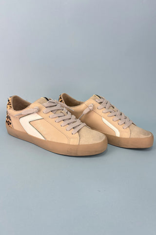 Pair of beige sneakers on a light gray background