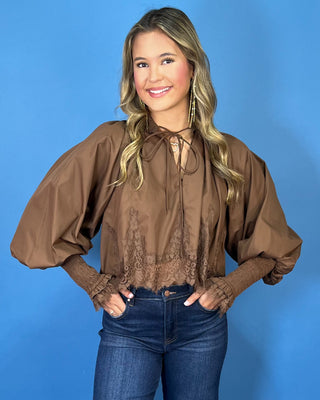 Chocolate brown lace trim blouse with voluminous balloon sleeves, smocked cuffs, and a feminine tie-neck detail.