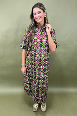 Woman wearing a patterned dress on a green background