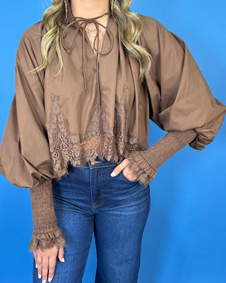 Chocolate brown lace trim blouse with voluminous balloon sleeves, smocked cuffs, and a feminine tie-neck detail.