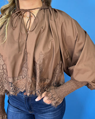 Chocolate brown lace trim blouse with voluminous balloon sleeves, smocked cuffs, and a feminine tie-neck detail.