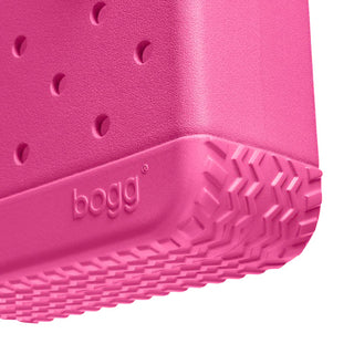 Close-up of a pink rubber shoe with 'bogg' branding on a white background
