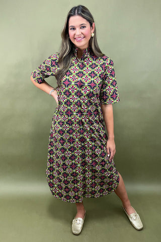 Woman wearing a patterned dress on a green background