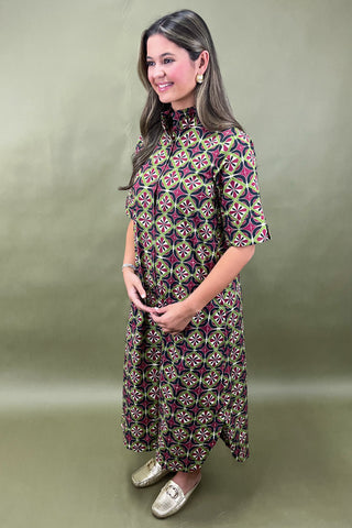 Woman wearing a patterned dress against a plain background