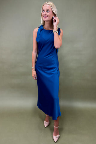 Woman wearing a blue dress against a plain background