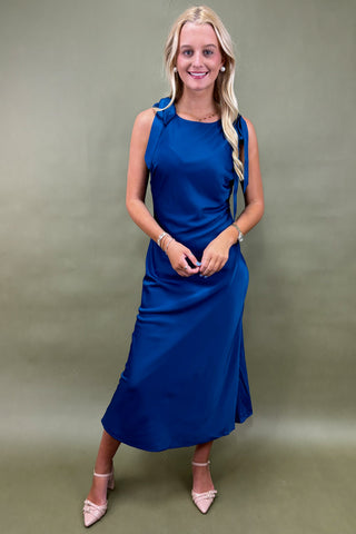 Woman wearing a blue dress against a green background