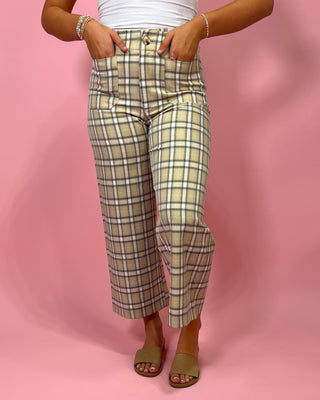 Plaid pants worn by a person on a pink background