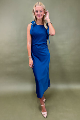 Woman wearing a blue dress against a green background