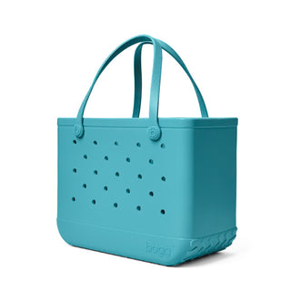 Turquoise tote bag with perforated design on a white background