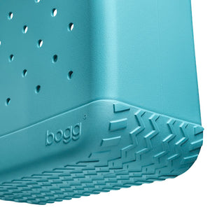 Close-up of a teal bogg planter with textured bottom and brand name.