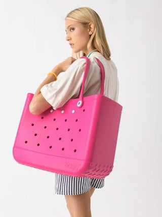 Person holding a pink tote bag with a white background