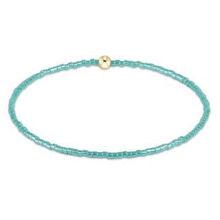 Turquoise beaded necklace with a gold clasp on a white background