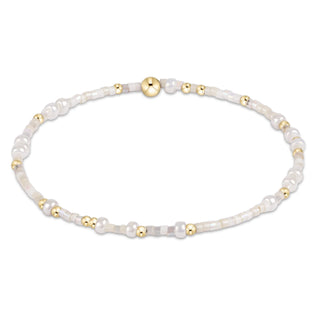 Pearl and gold beaded bracelet on a white background