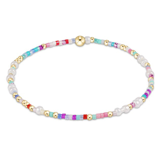 Multicolored beaded bracelet with gold accents on a white background