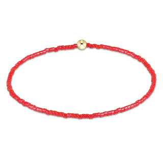 Red beaded bracelet with a gold clasp on a white background