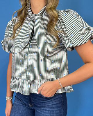 Ivory and black striped puff sleeve blouse with light blue polka dots, a statement tie neckline, button front, and ruffle hem.
