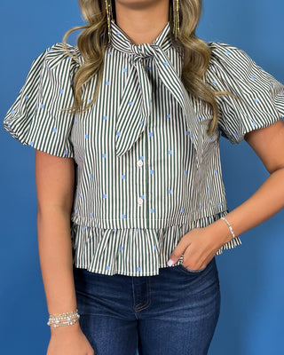 Ivory and black striped puff sleeve blouse with light blue polka dots, a statement tie neckline, button front, and ruffle hem.