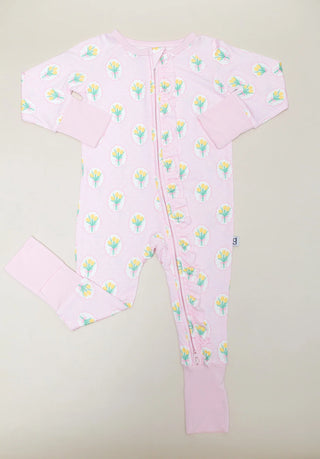 A baby long-sleeve footless one-piece sleeper in light pink, featuring a repeating pattern of yellow tulips with green leaves and a snap-button front closure.