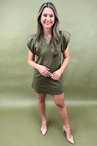 Woman wearing a green dress against a green background